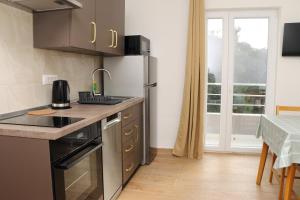 a kitchen with a stainless steel refrigerator and a table at Apartmani Mary S2 in Kukljica +12 photos