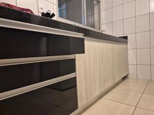 a kitchen with wooden cabinets and a black counter top at Fabuloso AP em Sete Lagoas in Sete Lagoas