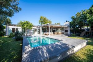 ein Hinterhof mit einem Swimmingpool und einem Haus in der Unterkunft Luxurious villa with the best facilities at the foot of the Constantia Valley in Doordrift