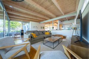 ein Wohnzimmer mit Sofa und Tisch in der Unterkunft Luxurious villa with the best facilities at the foot of the Constantia Valley in Doordrift