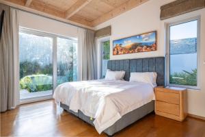ein Schlafzimmer mit großem Bett und großen Fenstern in der Unterkunft Luxurious villa with the best facilities at the foot of the Constantia Valley in Doordrift + 60 Fotos