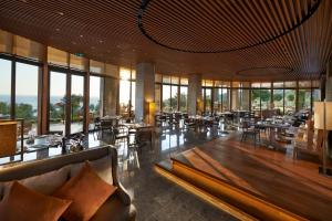 a restaurant with tables and chairs and windows at Mandarin Oriental, Bodrum in Golturkbuku