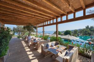 a person walking on a wooden deck near a pool at Mandarin Oriental, Bodrum in Golturkbuku