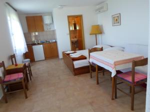 a kitchen and dining room with a table and chairs at Apartmani Rozić Zaostrog in Podaca