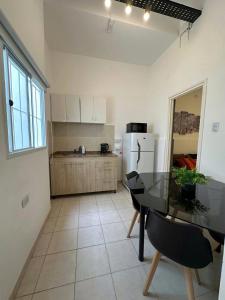 a kitchen with a glass table and a refrigerator at Departamento Esquiú in San Fernando del Valle de Catamarca