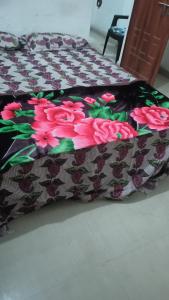 ein Bett mit einer Decke mit Blumen darauf in der Unterkunft Star hostel 3 km from sangam in Prayagraj