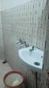 ein Badezimmer mit einem weißen Waschbecken und einem Mülleimer in der Unterkunft Star hostel 3 km from sangam in Prayagraj