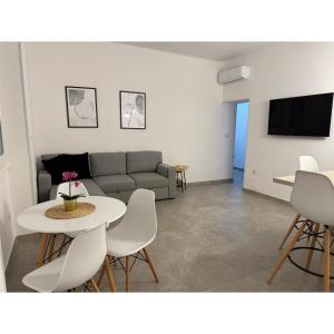a living room with a couch and a table and chairs at Salento Apartment in Brindisi