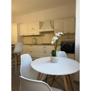 a kitchen with a white table and white chairs at Salento Apartment in Brindisi