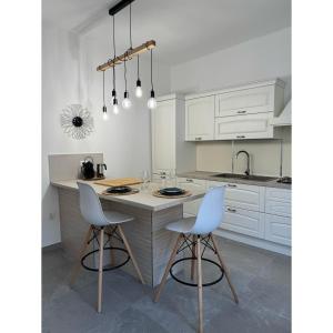 a kitchen with white cabinets and a table and chairs at Salento Apartment in Brindisi
