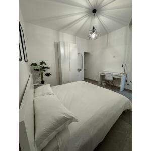 a white bedroom with a large bed and a desk at Salento Apartment in Brindisi +17 photos