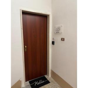 a brown door in a hallway with a sign on the wall at Salento Apartment in Brindisi