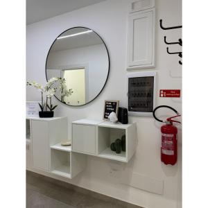 a mirror on a white shelf in a room at Salento Apartment in Brindisi