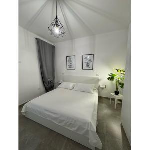 a bedroom with a white bed and a potted plant at Salento Apartment in Brindisi