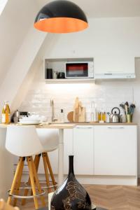 a kitchen with a table and a black lamp at La Canopée - calme au coeur de Fougères in Fougères +18 photos