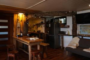 a kitchen with a table and a refrigerator at Refugio Jemmy Button in Puerto Williams