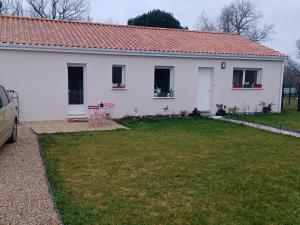 a white house with a red roof and a yard at Les hortensias in Soubran