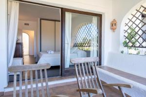 a room with two chairs and a table and a bedroom at Orizzonte Blu 103 in Liscia di Vacca