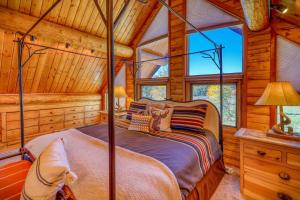 una camera con un letto in una baita di tronchi di 218 Buttress Ave a Pagosa Springs