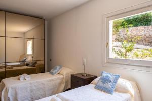 a bedroom with two beds and a large window at Orizzonte Blu 103 in Liscia di Vacca