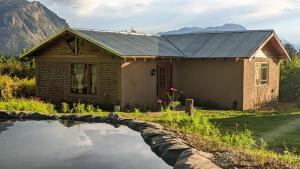 une maison avec un étang devant dans l'établissement La Cristalina, à El Hoyo
