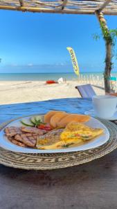 a plate of breakfast food on a table at the beach at Palaa Mayapo Ecolodge in Mayapo +38 photos