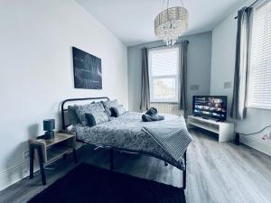 a bedroom with a bed and a flat screen tv at Jacksons Modern Retreat Close to Tynemouth in Tynemouth