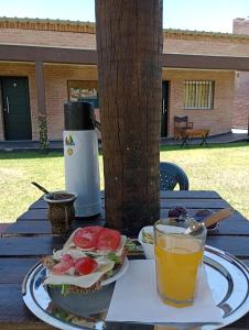 a plate with a sandwich and a drink on a table at Posada Entre Dos in Mina Clavero