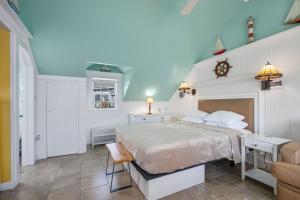 a bedroom with a white bed and a chair at Seaside Cottages - Cottage 16 - Beach Cottage in South Yarmouth