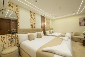 una habitación de hotel con dos camas y una silla en The Muse Pyramids Lodge, en El Cairo 107 fotos más