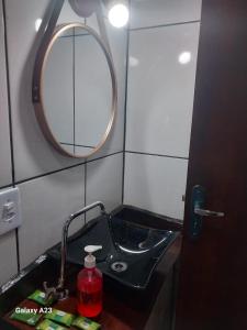 a bathroom with a black sink and a mirror at Morada do Sabiá - chalé 2 in Resende +10 photos