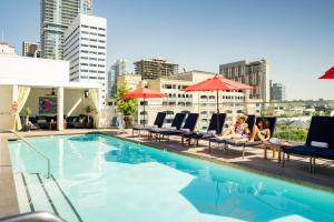 a group of people sitting on chairs next to a swimming pool at Andaz San Diego, By Hyatt in San Diego