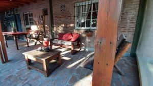 a patio with wooden furniture and a brick wall at Punta del Sur in San Clemente del Tuyú