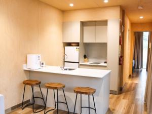 cocina con encimera y 2 taburetes en BIG4 Carnarvon Gorge Holiday Park, en Carnarvon Gorge