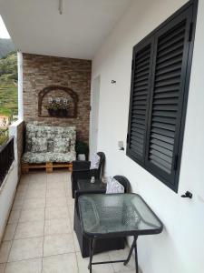 a patio with chairs and a couch on a balcony at Marques House in Machico