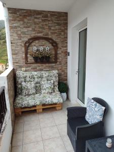 a couch on a balcony with a brick wall at Marques House in Machico