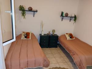 a bedroom with two beds and a dresser and a mirror at Marques House in Machico