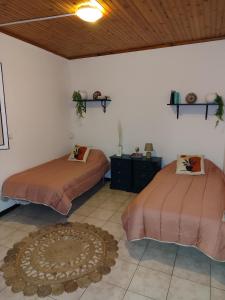 a bedroom with two beds and a rug at Marques House in Machico