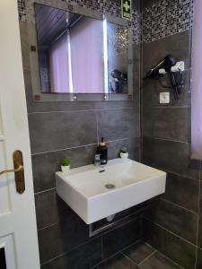 a bathroom with a white sink and a mirror at Marques House in Machico
