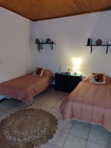 a bedroom with two beds and a table and a rug at Marques House in Machico +31 photos