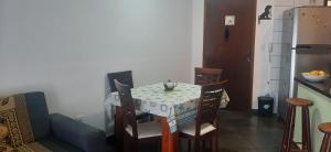 a table and chairs in a kitchen with a table and a refrigerator at Apartamento Relax Enseada Bertioga SP in Bertioga