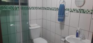 a bathroom with a shower and a toilet and a sink at Apartamento Relax Enseada Bertioga SP in Bertioga +3 photos