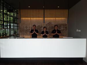 a group of three women standing in front of a mirror at Tama Boutique Hotel in Bandung