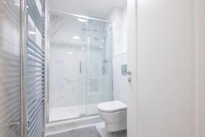a white bathroom with a shower and a toilet at 2nd Floor Stylish 2-Bed Apartment in Drogheda +7 photos