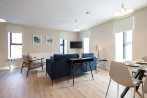 a living room with a blue couch and a table at 2nd Floor Stylish 2-Bed Apartment in Drogheda