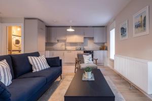 a living room with a blue couch and a kitchen at 2nd Floor Stylish 2-Bed Apartment in Drogheda