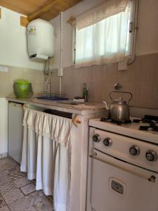 a kitchen with a stove and a pot on the counter at Aimara Casas de alquiler in Mina Clavero +4 photos