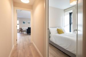 a bedroom with a bed and a hallway with a table at 2nd Floor Stylish 2-Bed Apartment in Drogheda