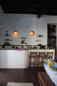 a kitchen with a counter with chairs and a table at Centro Cultural do Bispo Guesthouse in Salvador