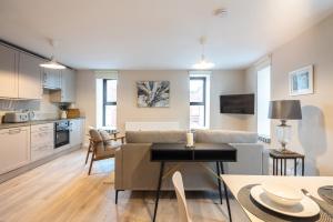 a living room with a couch and a table at 3rd Floor Stylish 2-Bed Apartment in Drogheda
